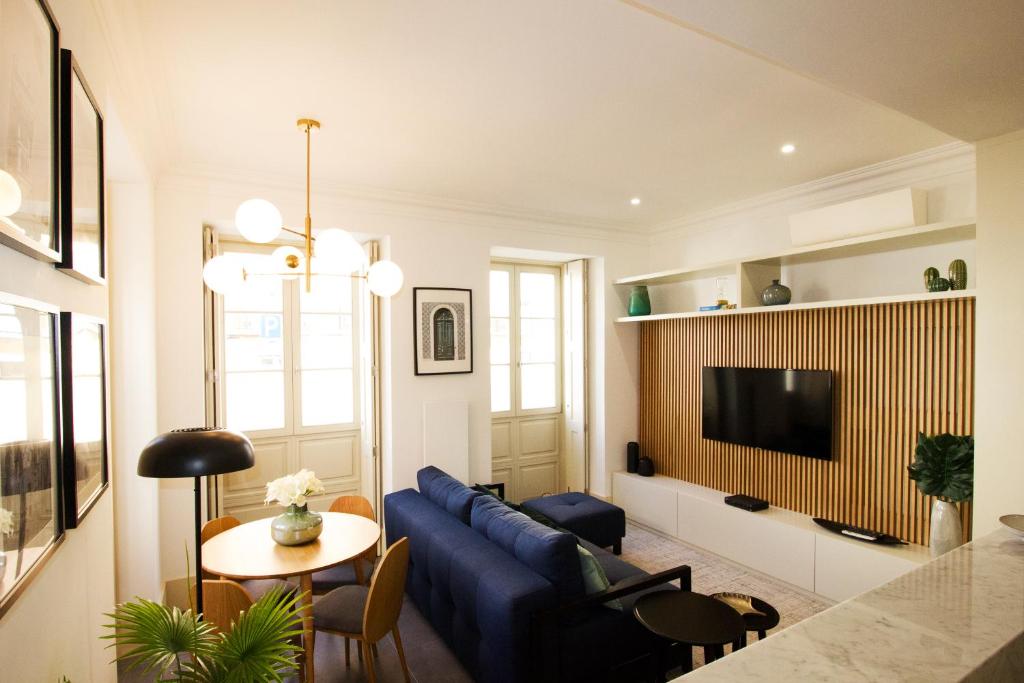 sala de estar con sofá azul y mesa en FLH Lapa Design Apartment with Terrace, en Lisboa