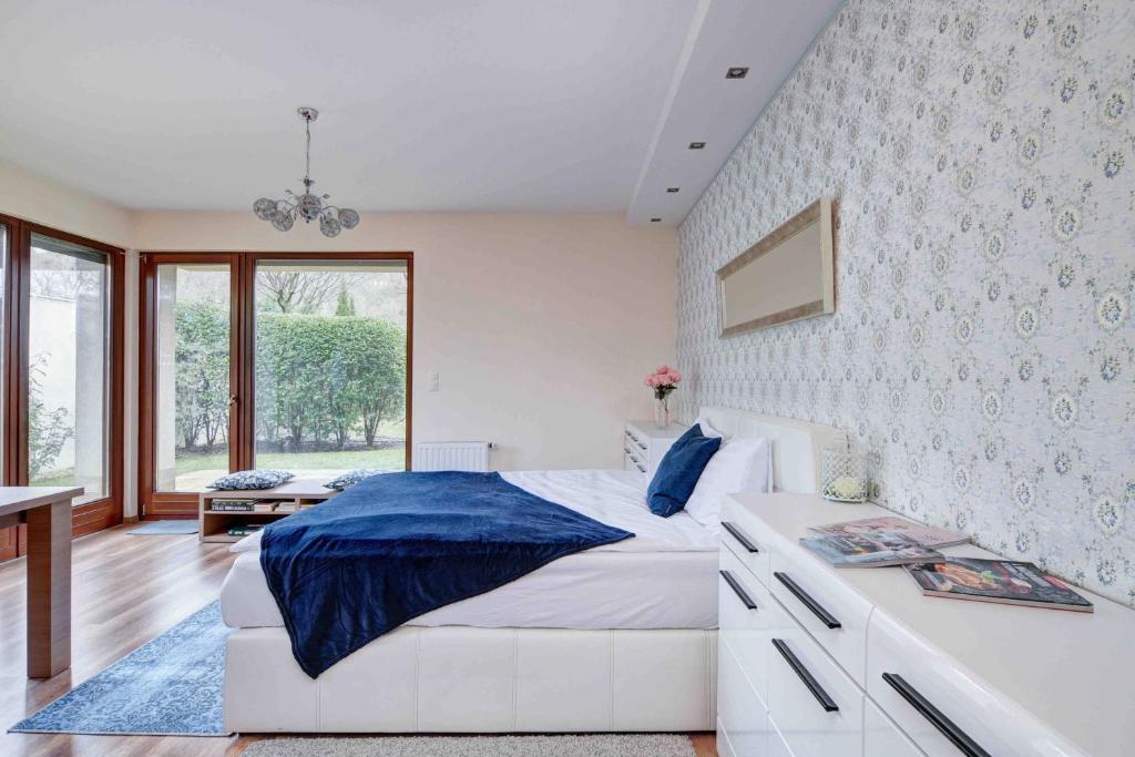 ein Schlafzimmer mit einem großen weißen Bett und einem Fenster in der Unterkunft Madarhegy Apartment with garden Buda side in Budapest