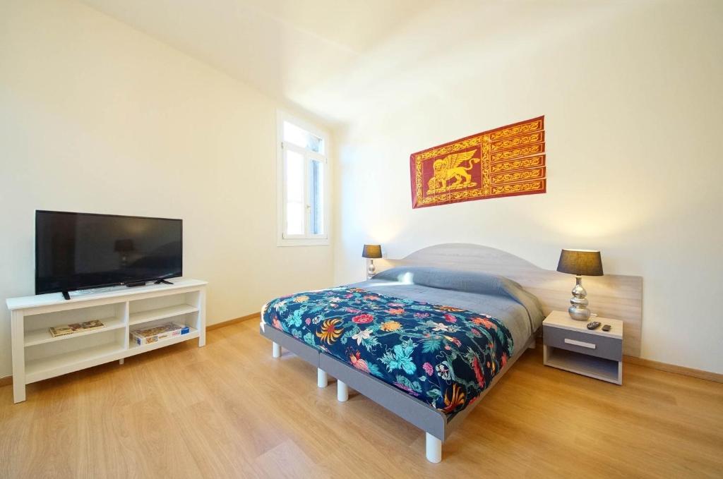 een slaapkamer met een bed en een flatscreen-tv bij Ca' Circus 4 Rooms WI-FI Fibre in Venetië