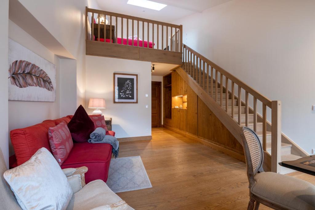 a living room with a red couch and a staircase at Augustiner in Meran in Merano