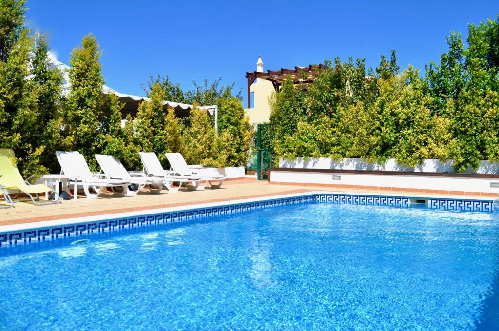 een zwembad met ligstoelen en een zwembad bij Villa ELTAEL - Casa Daniel - Piscina Aquecida e Partilhada in Manta Rota