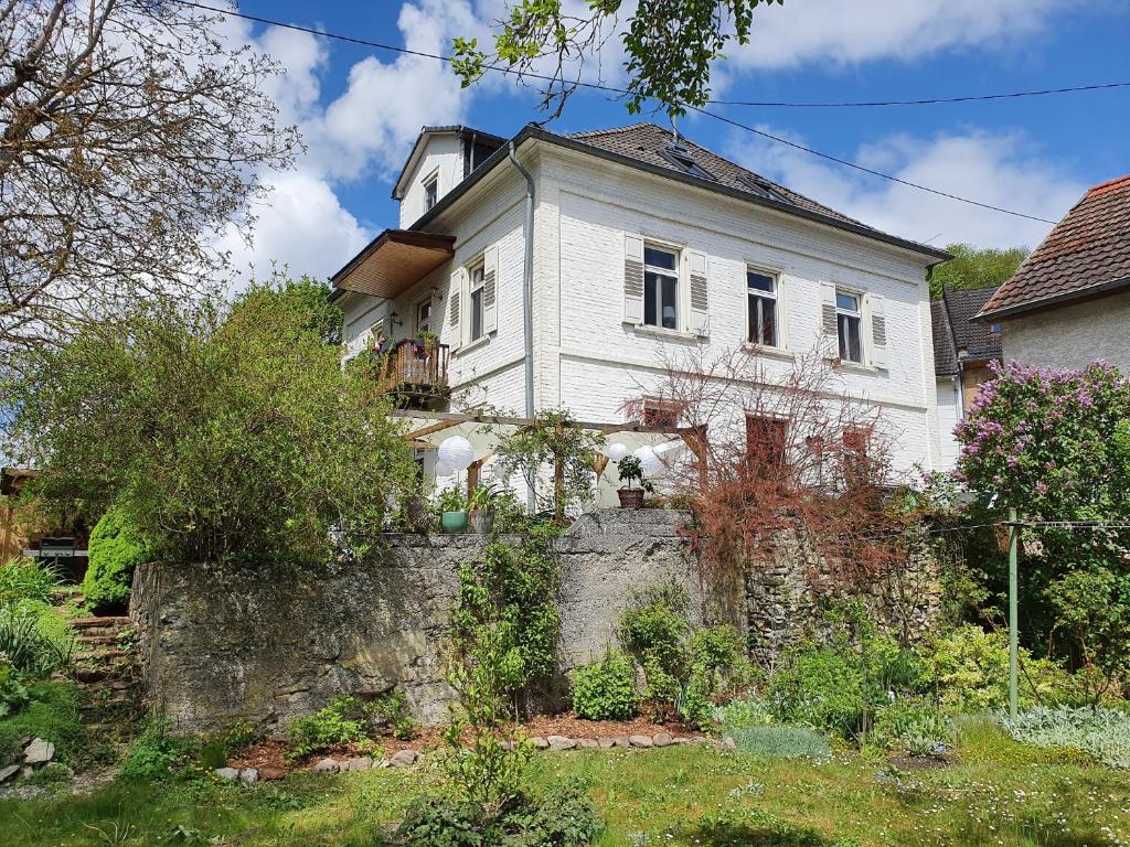 una casa blanca en la parte superior de una pared de piedra en Villa Adelinde, en Stromberg