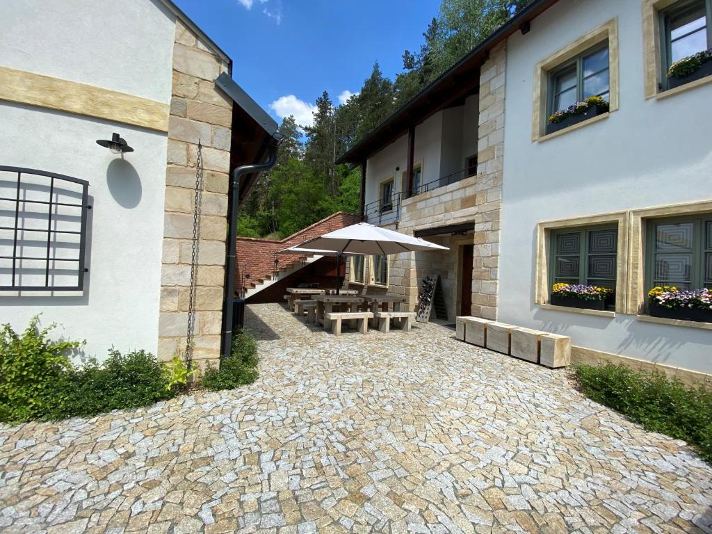 patio ze stołem i parasolem obok budynku w obiekcie Penzion Stodola w mieście Weisswasser in Böhmen