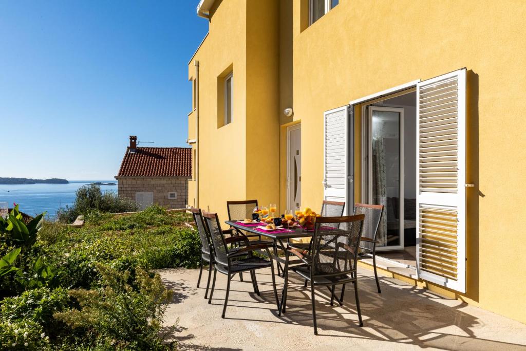 - une table et des chaises sur une terrasse avec vue sur l'océan dans l'établissement Amarillo Apartments, à Mlini