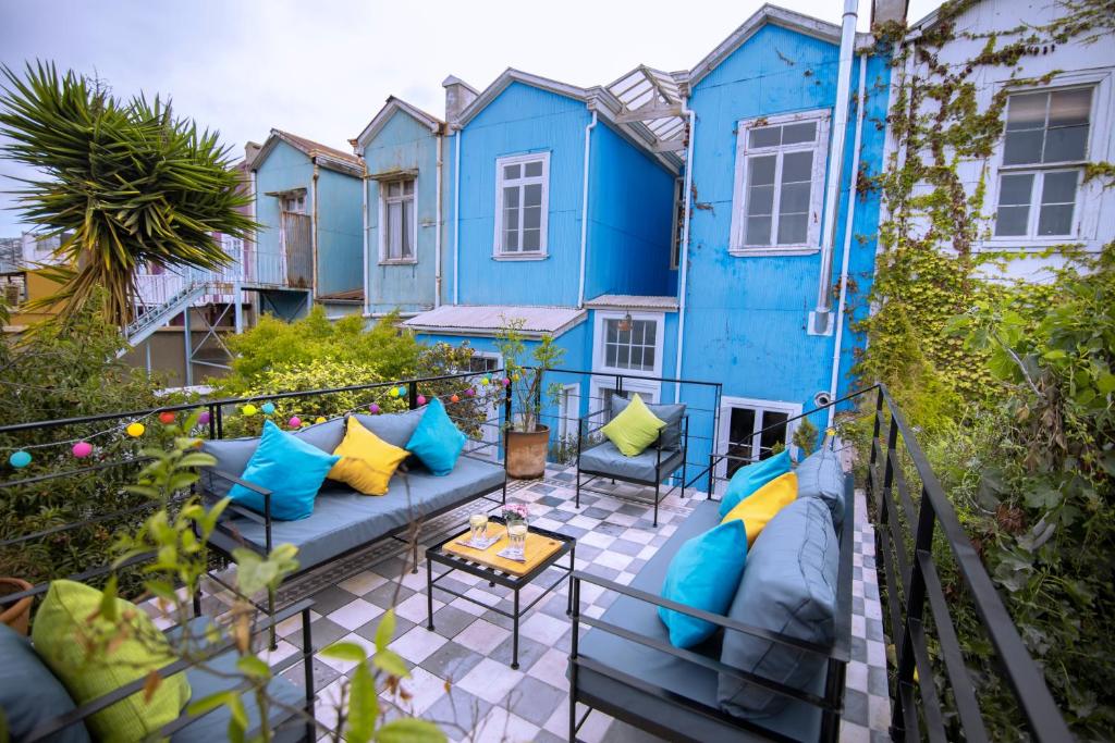 un patio con muebles azules y una casa azul en New Voga Guesthouse en Valparaíso