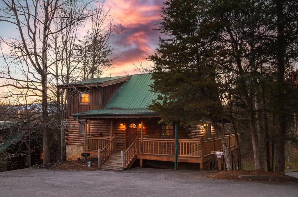 a log cabin with a porch and a green roof at Moose Tracks cabin in Pigeon Forge