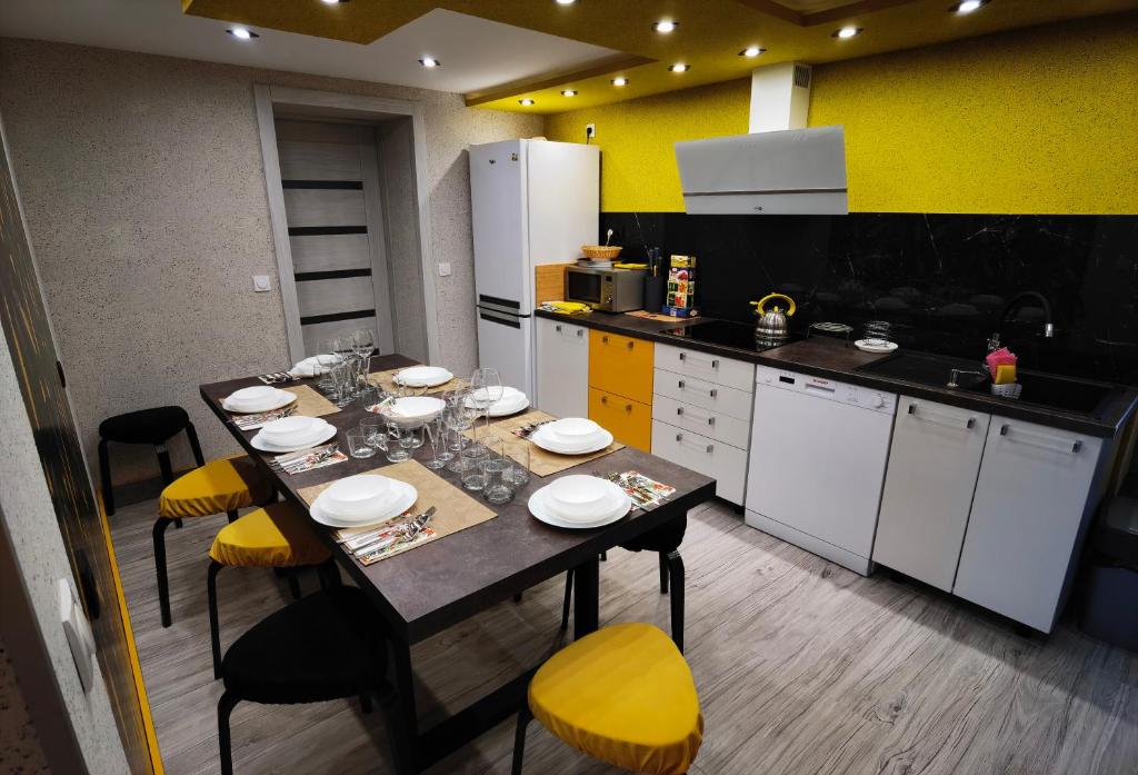 eine Küche mit einem Tisch mit gelben und weißen Geräten in der Unterkunft Pokoje u Orła w Szklarskiej Porębie in Szklarska Poręba