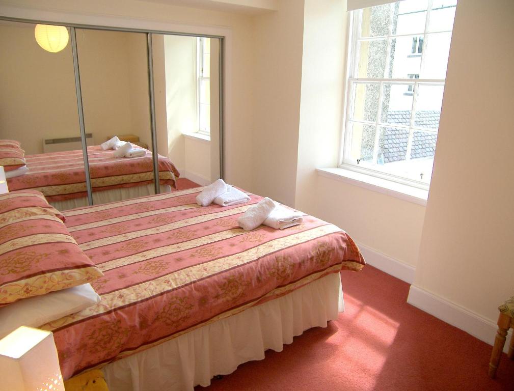 um quarto com 2 camas e um espelho grande em Royal Mile, Edinburgh - 2 Bedroom Apartment em Edinburgo
