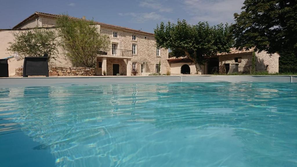 una gran piscina azul frente a un edificio en Domaine Chamarel, en Saint-Paulet-de-Caisson