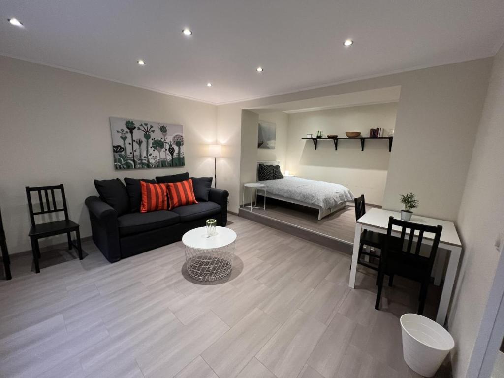 uma sala de estar com um sofá e uma cama em city rooms luxembourg em Luxemburgo