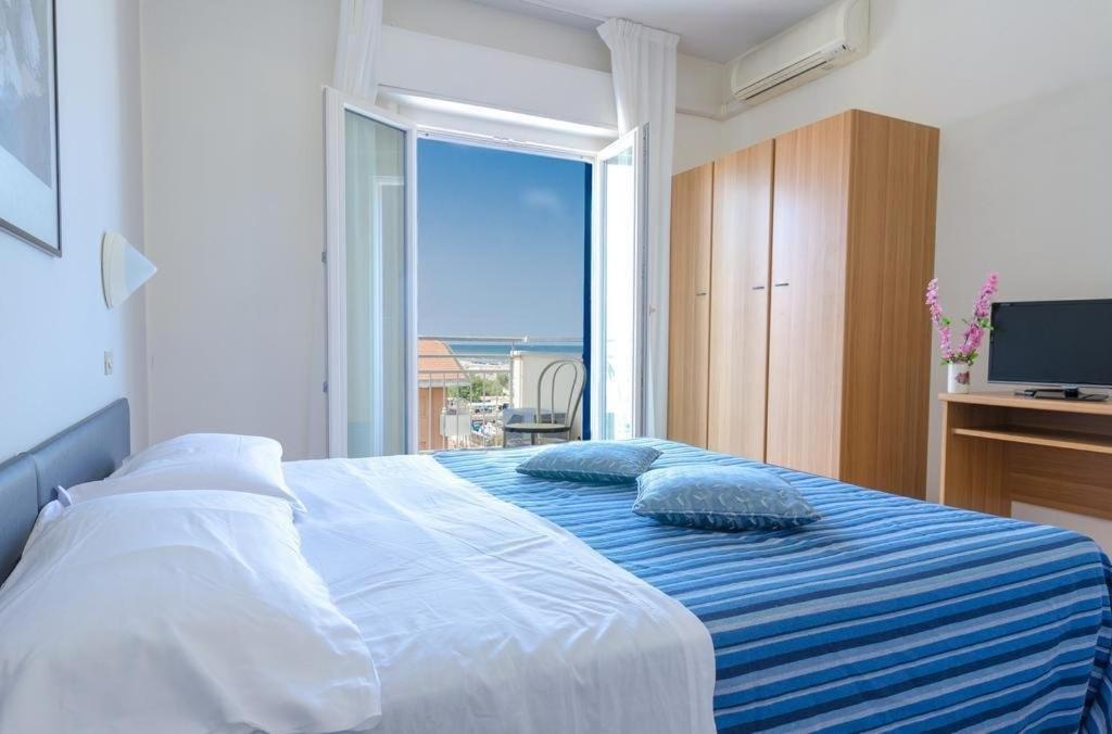 1 dormitorio con 1 cama y vistas al océano en Hotel Los Angeles - Fronte mare, en Riccione