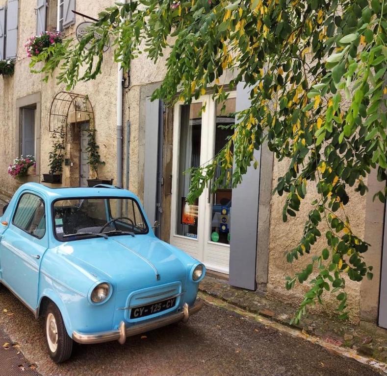 un coche azul estacionado frente a un edificio en L'Ancienne Boulangerie, en Caunes-Minervois