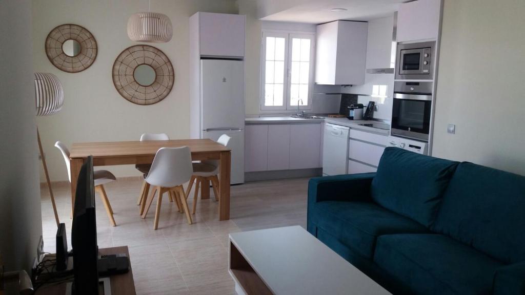 een woonkamer met een blauwe bank en een tafel bij Apartments Sol de Almeria Golf y Playa II in Almería