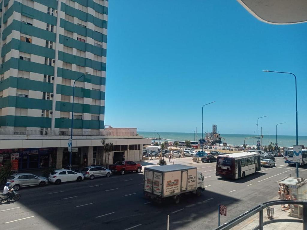 a busy city street with cars and a tall building at Hotel Avenida del Mar in Mar del Plata