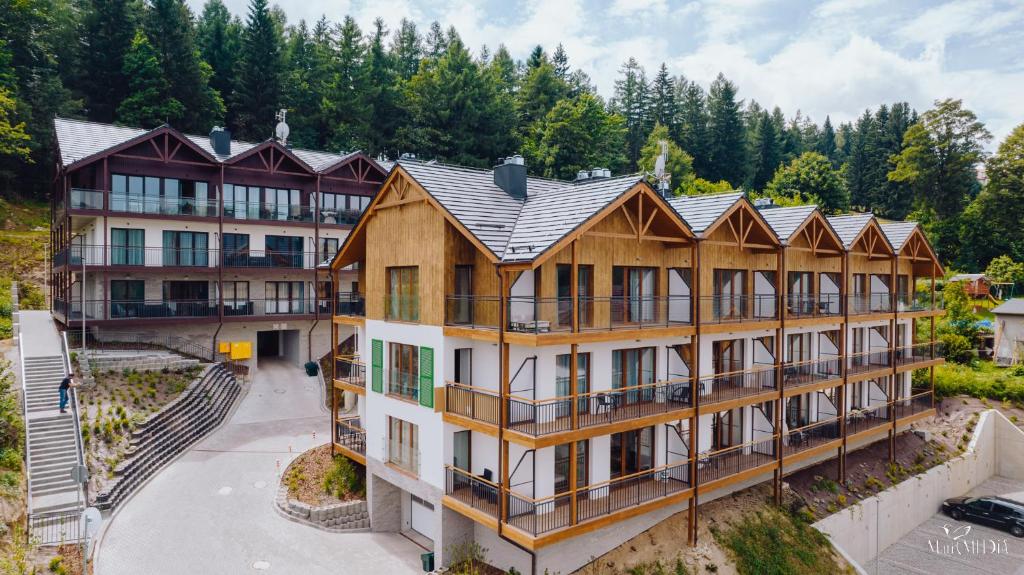 an aerial view of a resort building with trees in the background at Apartament Silence Karpatia Resort Koral in Karpacz