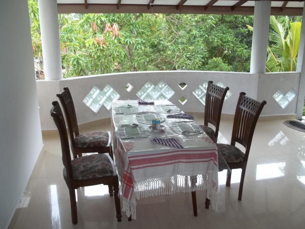 a dining room table with chairs and a tablecloth on it at Anura Home Stay in Kalutara