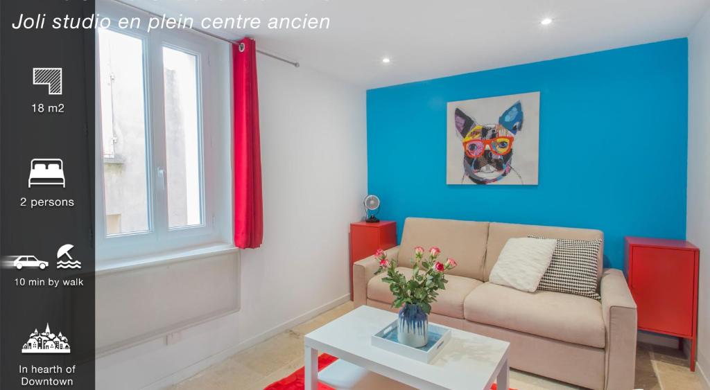 un salon avec un canapé et une peinture d'un chien dans l'établissement Le Saint Louis Blue Bulldog, à Hyères