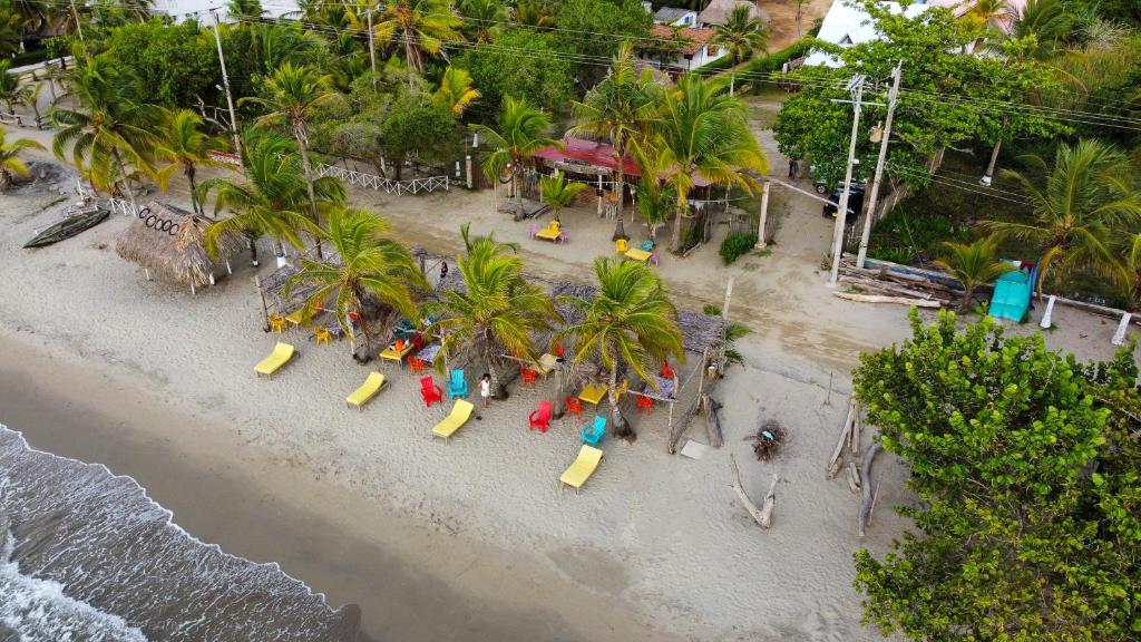 科韋尼亞斯的住宿－Mar Amar Cabaña - Hostel，享有棕榈树海滩的空中景致,设有游乐场