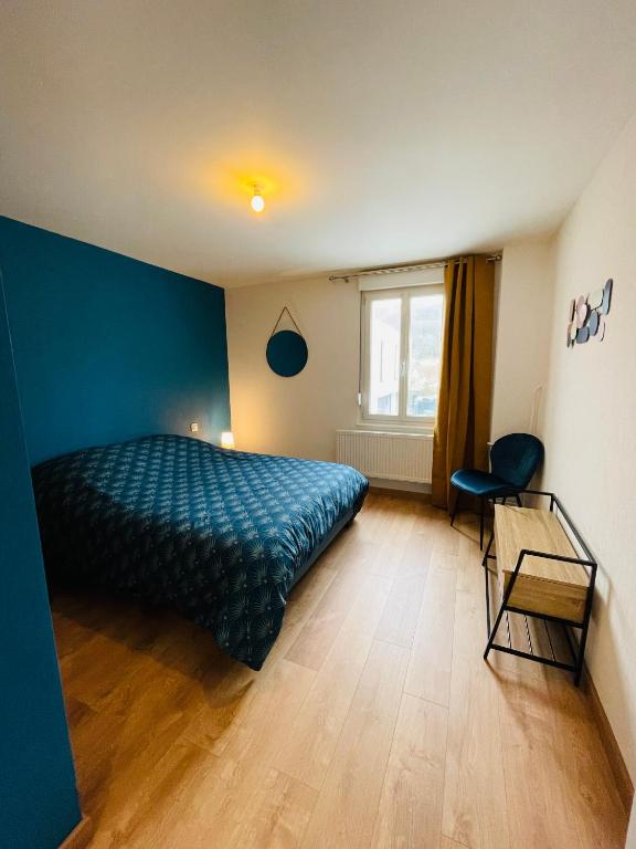 a bedroom with a bed and a blue wall at Appartement Les Tilleuls &quot;3 étoiles&quot; in Niederbronn-les-Bains