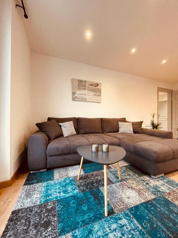 a living room with a couch and a table at Appartement Les Tilleuls &quot;3 étoiles&quot; in Niederbronn-les-Bains