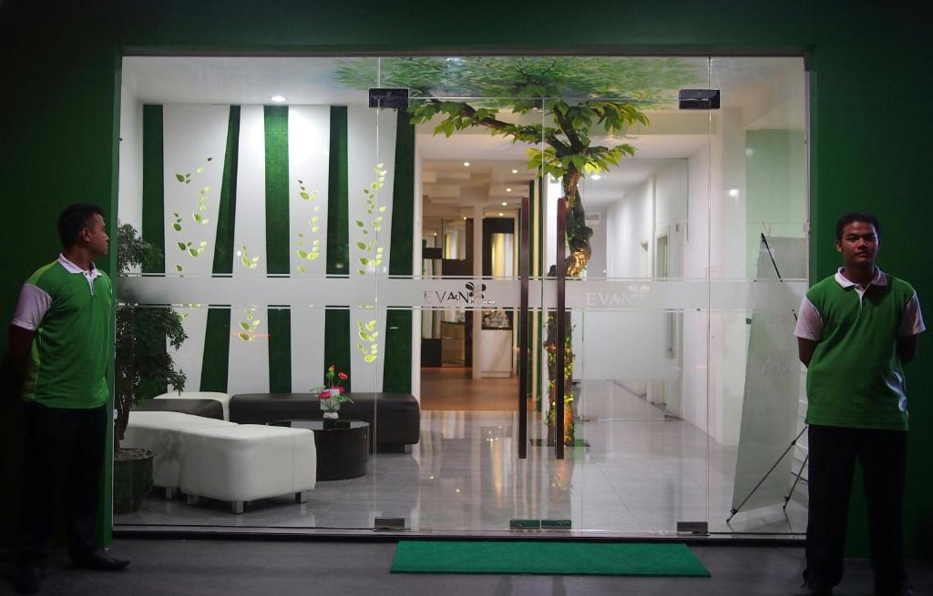 two men standing in front of a glass door in a lobby at Evan Hotel Jambi in Jambi