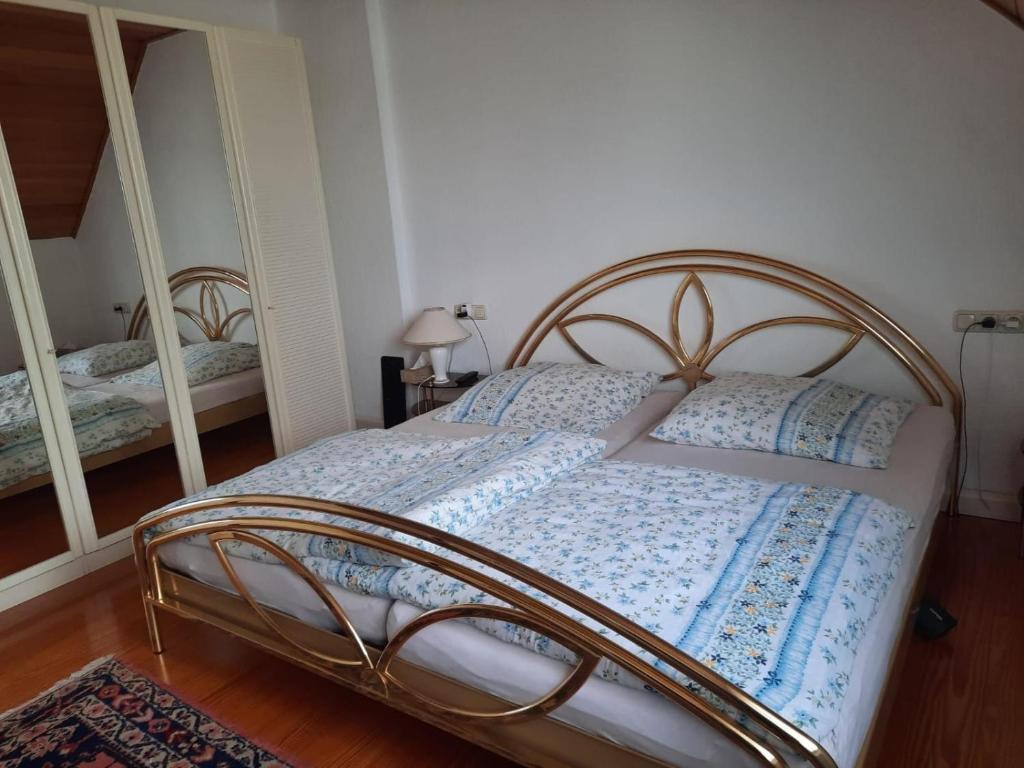 a bedroom with a bed with a blue and white comforter at Wohnen beim Uswatta Liyanage in Troisdorf
