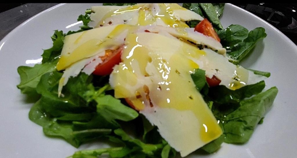 a white plate with a salad with cheese and vegetables at Guesthouse Lord Byron in Tepelenë