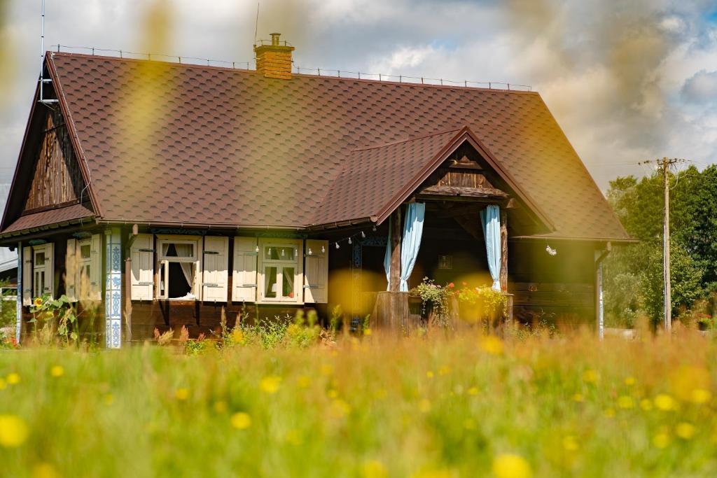 een huis met een betegeld dak in een grasveld bij Chata Łońska in Pultusk