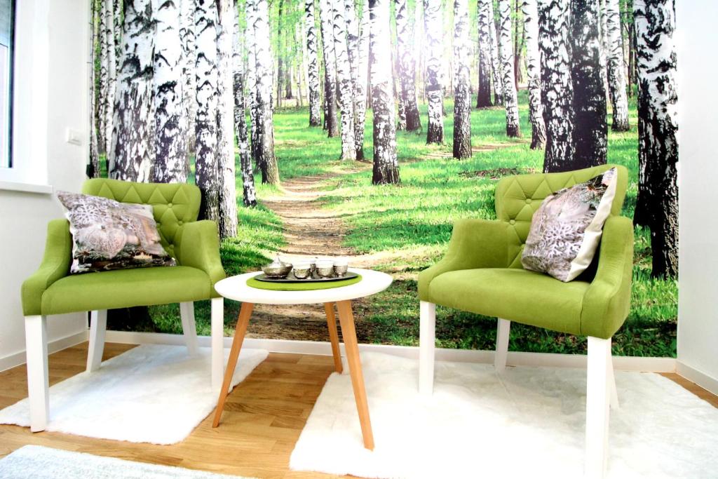a room with two chairs and a forest mural at Green Oasis in Bjelašnica