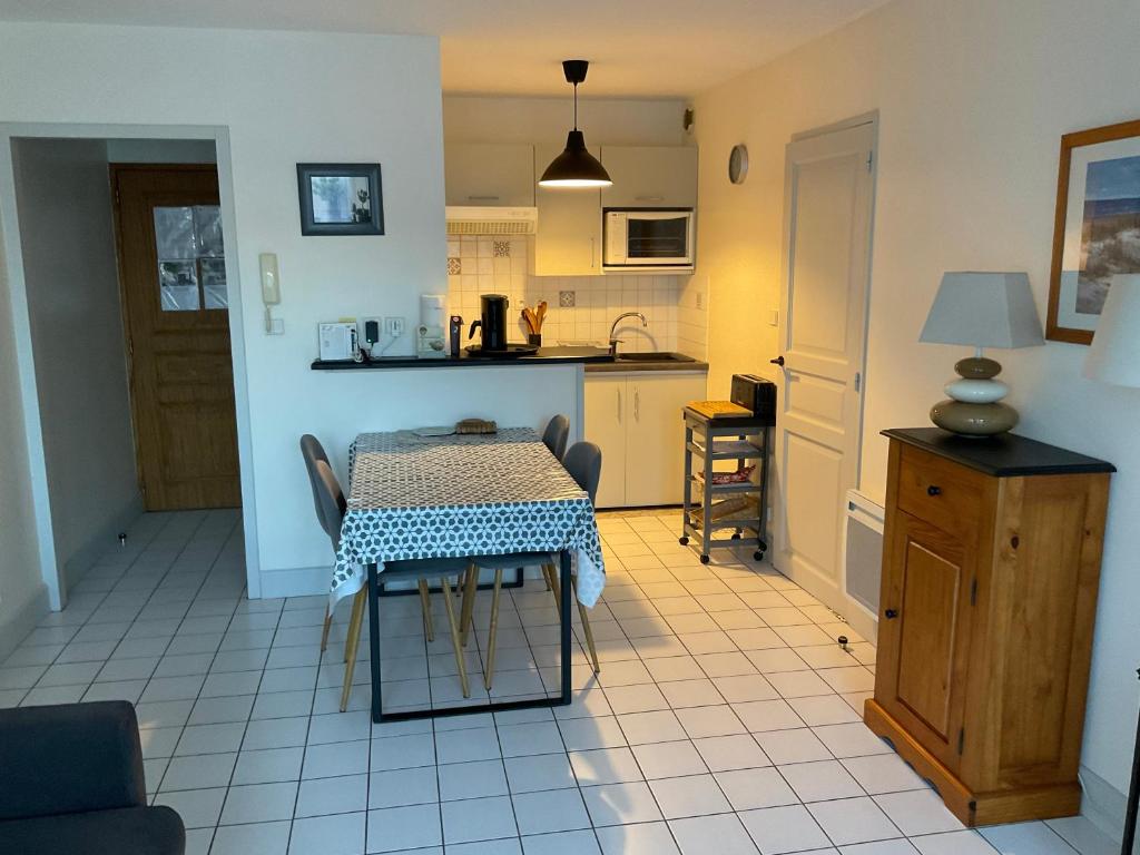 une cuisine avec une table et une petite cuisine avec une table et des chaises dans l'établissement Appartement centre ville près du port avec parking et wifi, à La Rochelle