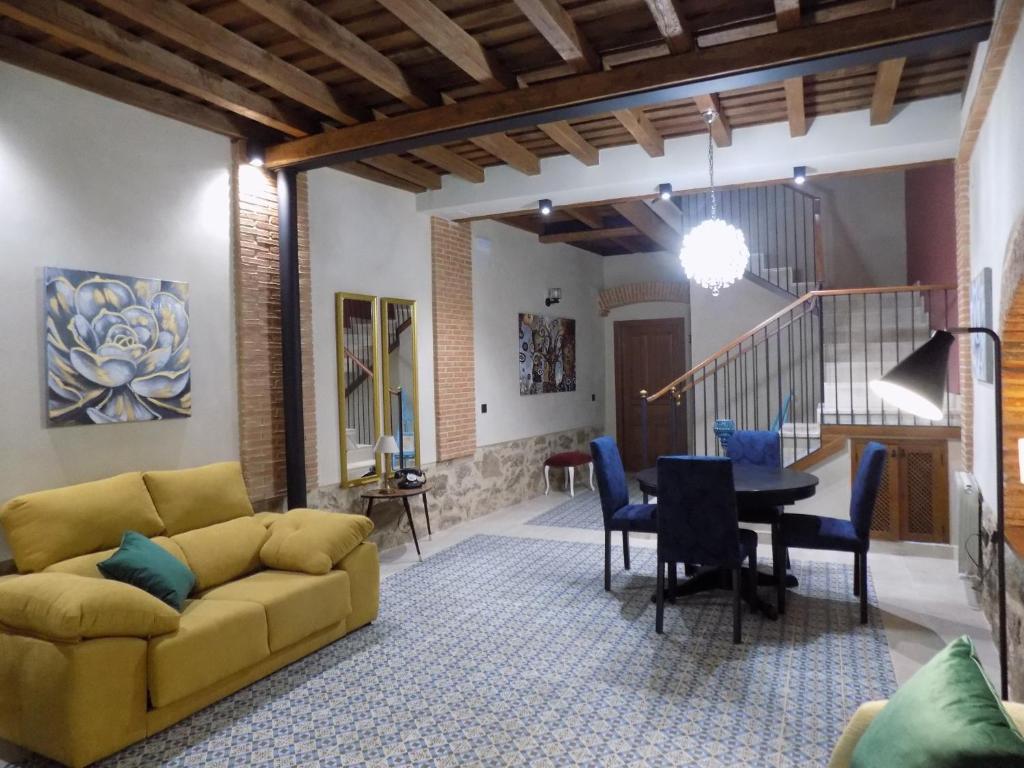 a living room with a yellow couch and a table at Apartamentos Suite Puerta del Jerte in Plasencia