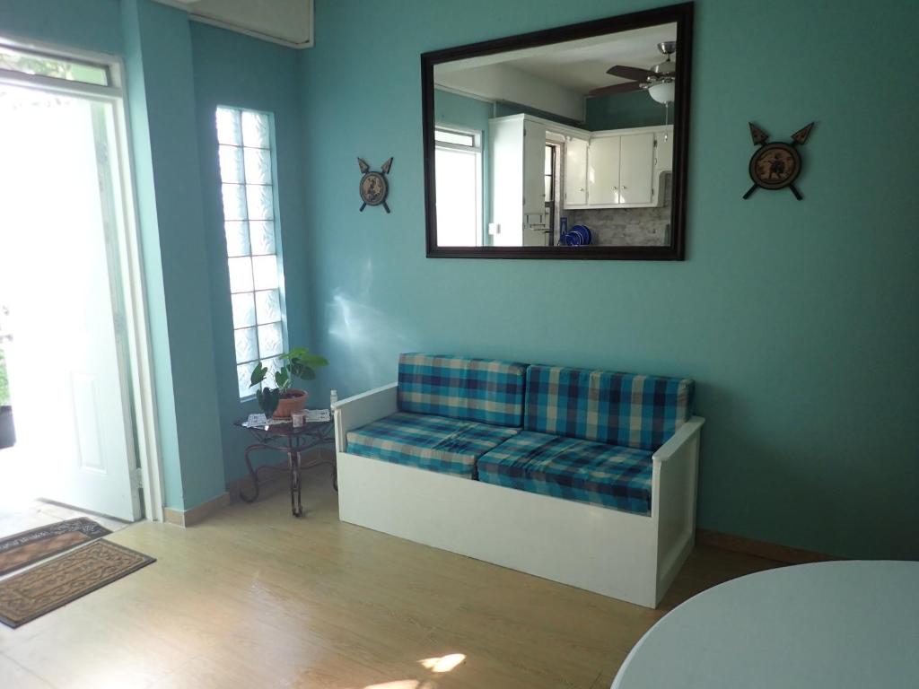 a blue room with a couch and a mirror at Urban Oasis Apartment in Castries