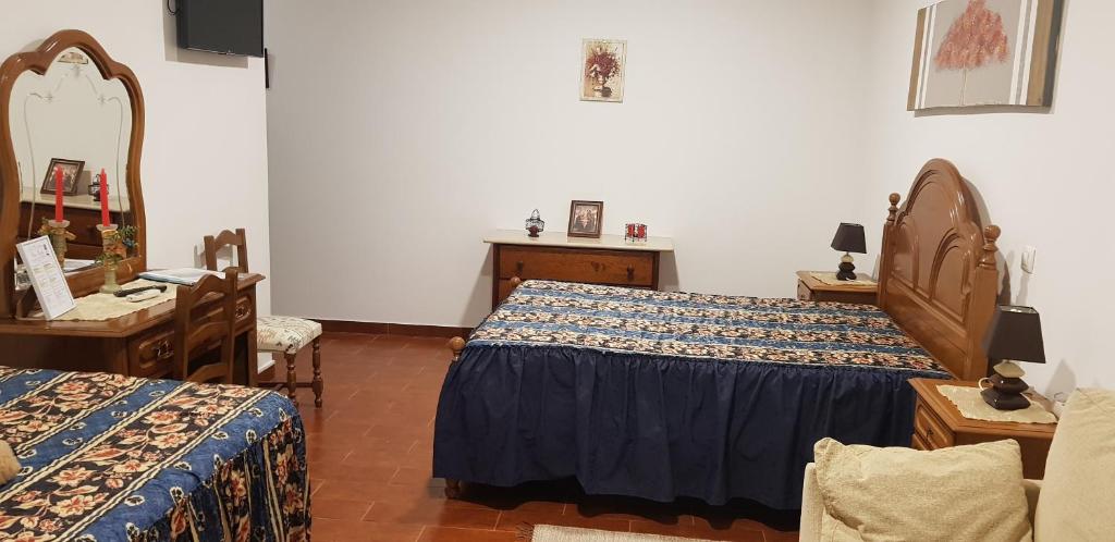 - une chambre avec 2 lits, une table et un miroir dans l'établissement Alojamento Local Céu-Azul, à Porto de Mós