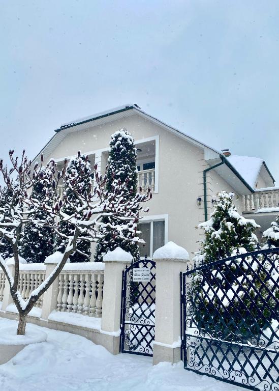 a house with a fence and snow covered trees at Вилла Поляна in Polyana