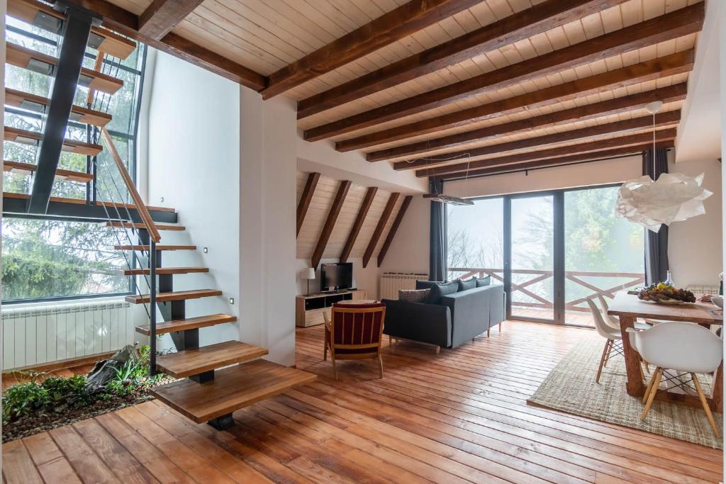 una sala de estar con una escalera de caracol y una mesa en Vista Mountain House en Kopaonik