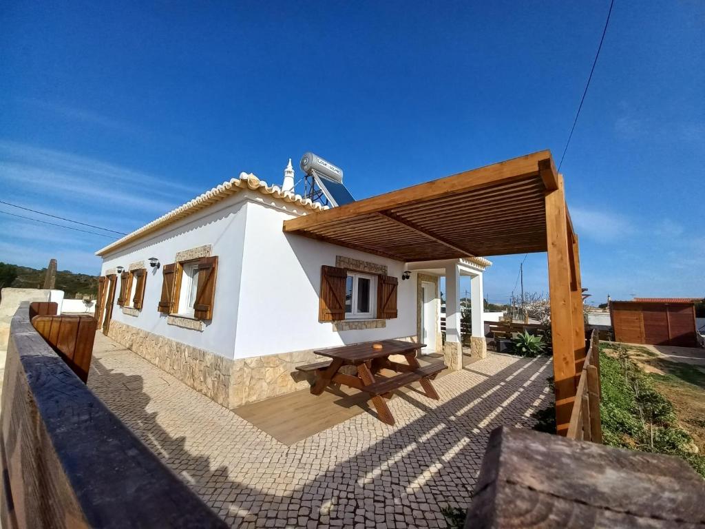 una piccola casa con un tavolo da picnic di fronte di Casa Pinheirinho a Sagres