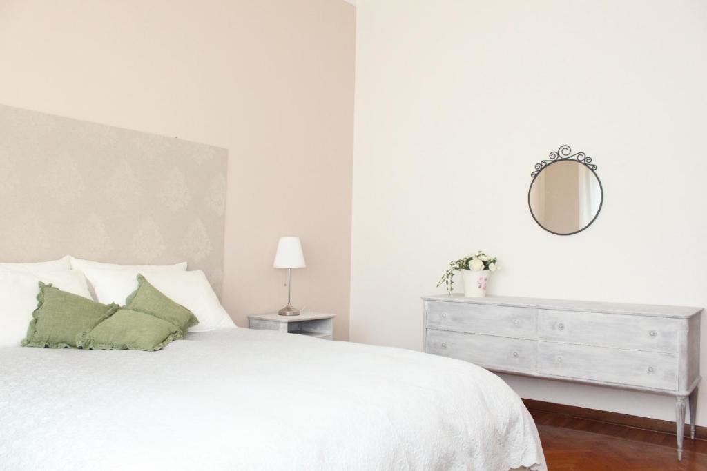 a white bedroom with a white bed and a mirror at B&B Abano Garden in Abano Terme