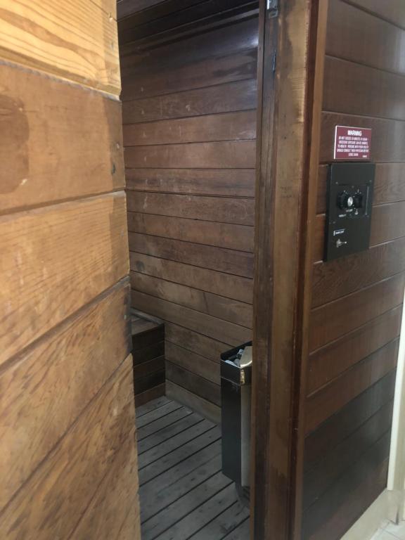 a bathroom with wooden walls and a trash can at Naples Dream at WTC with Heated Pool SPA Sauna 7 bicycles and 3 mls to beach in Naples