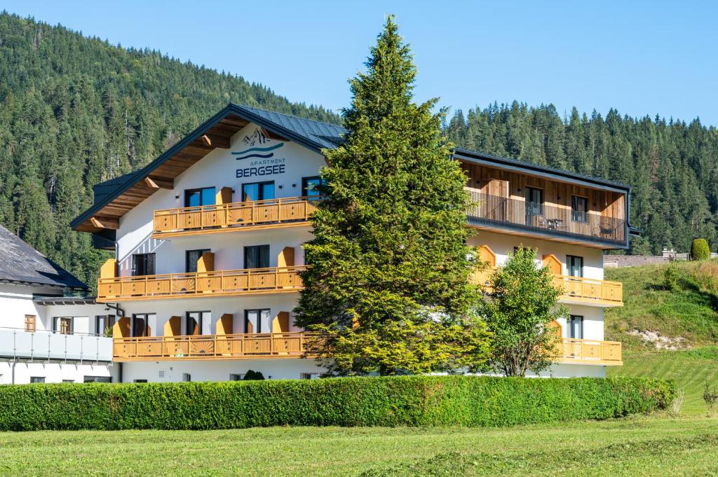 een groot gebouw met een boom ervoor bij Apartment Bergsee in Lunz am See