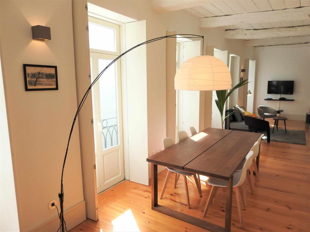 a dining room with a table and a lamp at Oporto Delight 2 Luxury Apartment in Historic Center Max 4p in Porto
