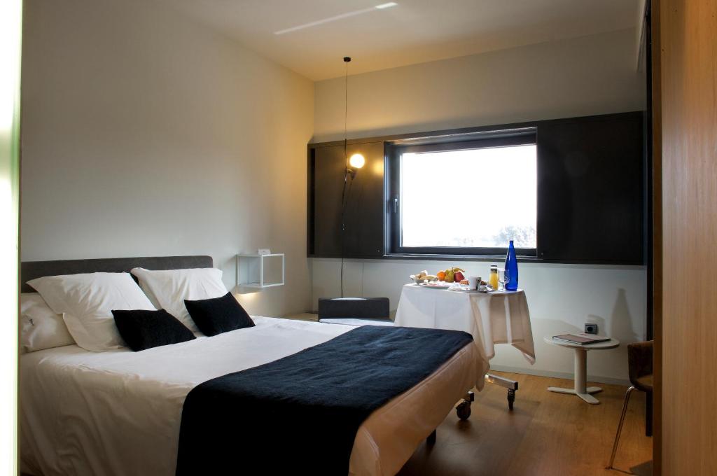 ein Schlafzimmer mit einem Bett und einem Tisch darin in der Unterkunft Blu Hotel Almansa in Almansa