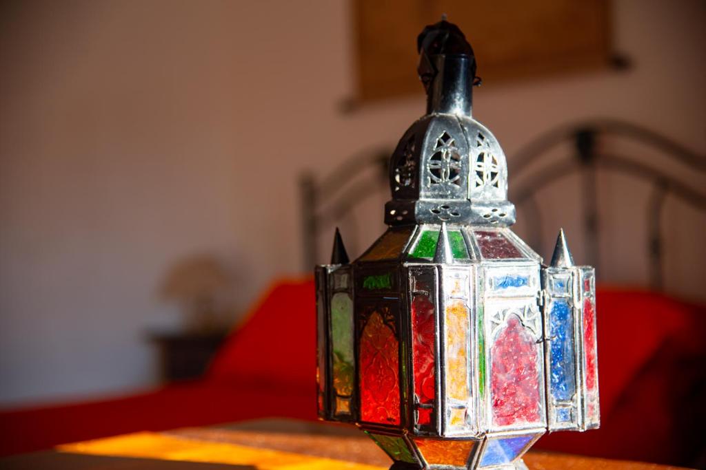 una lanterna a vetri colorati seduta sopra un tavolo di Villa Carrieri a Marina di Lizzano
