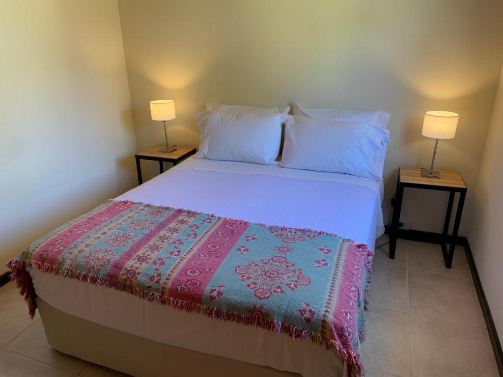 ein Schlafzimmer mit einem Bett mit zwei Lampen an zwei Tischen in der Unterkunft Las Rucas in San Martín de los Andes
