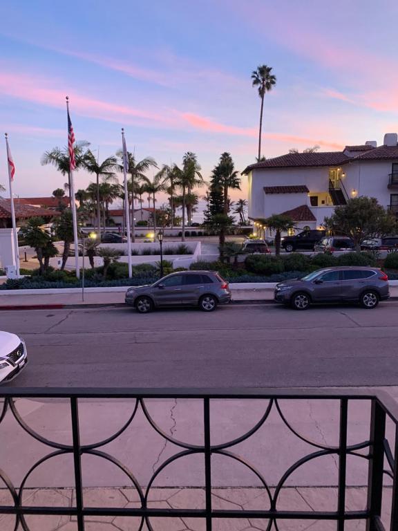 zwei Autos auf einem Parkplatz mit Palmen geparkt in der Unterkunft Inn at East Beach in Santa Barbara