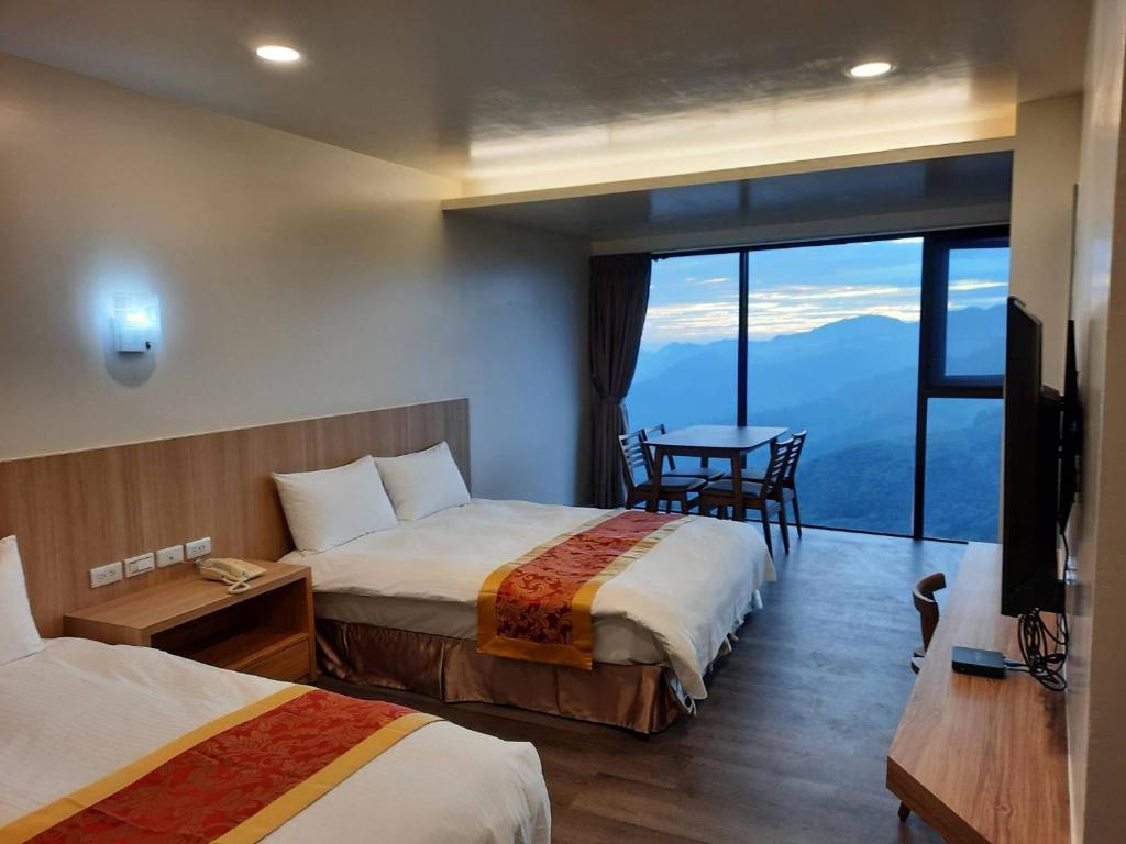 a hotel room with two beds and a table at Song Mao Homestay in Leye