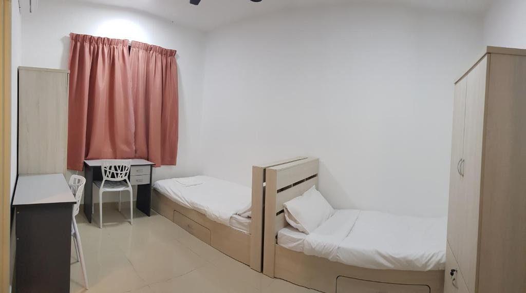 a room with two beds and a desk and a window at Family Staycation BYSS Homestay in Kampar