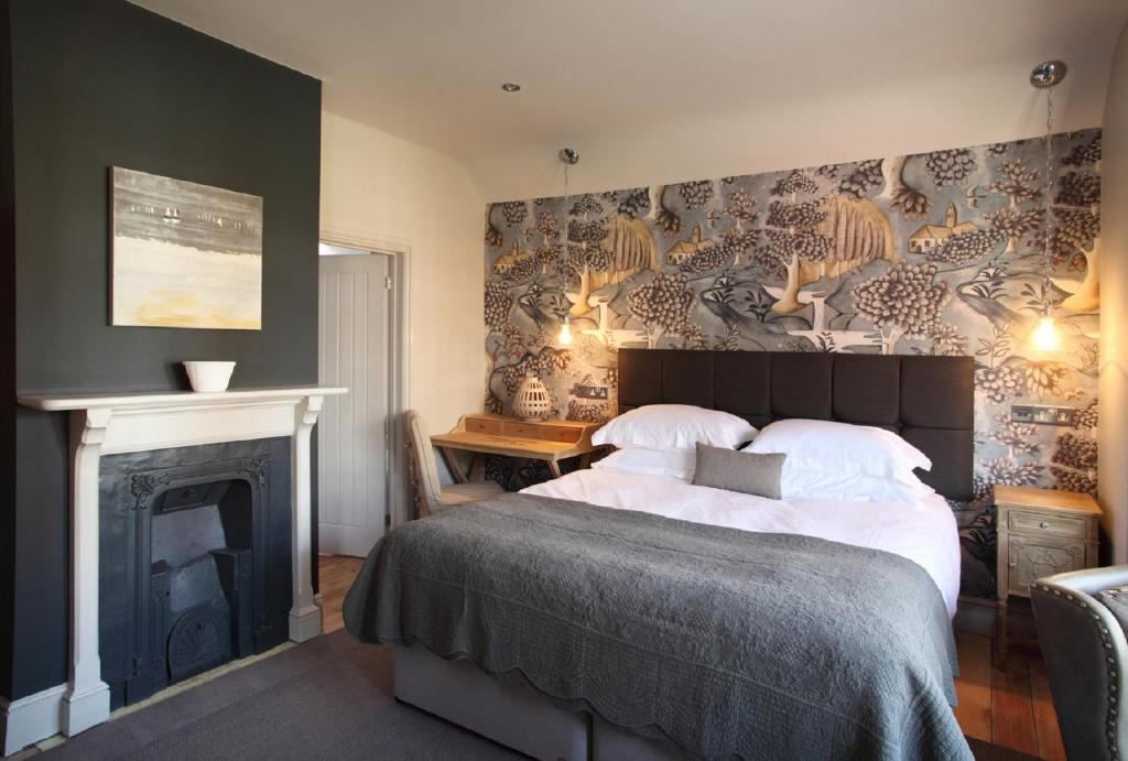 um quarto com uma cama grande e uma lareira em No33 HUNSTANTON BOUTIQUE ROOMS em Hunstanton