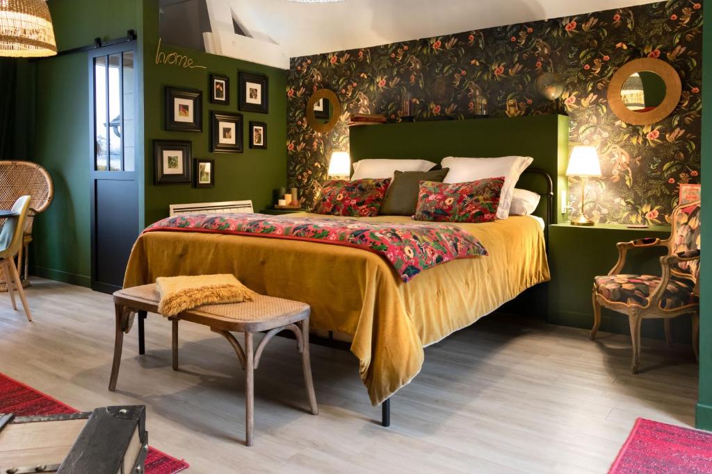 - une chambre avec un grand lit et des murs verts dans l'établissement Les Patis, à Vouvray