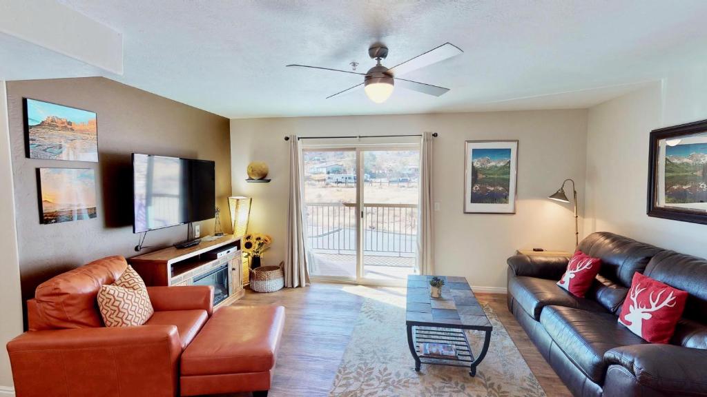 a living room with a couch and a flat screen tv at Red Cliff Condos #3E in Moab