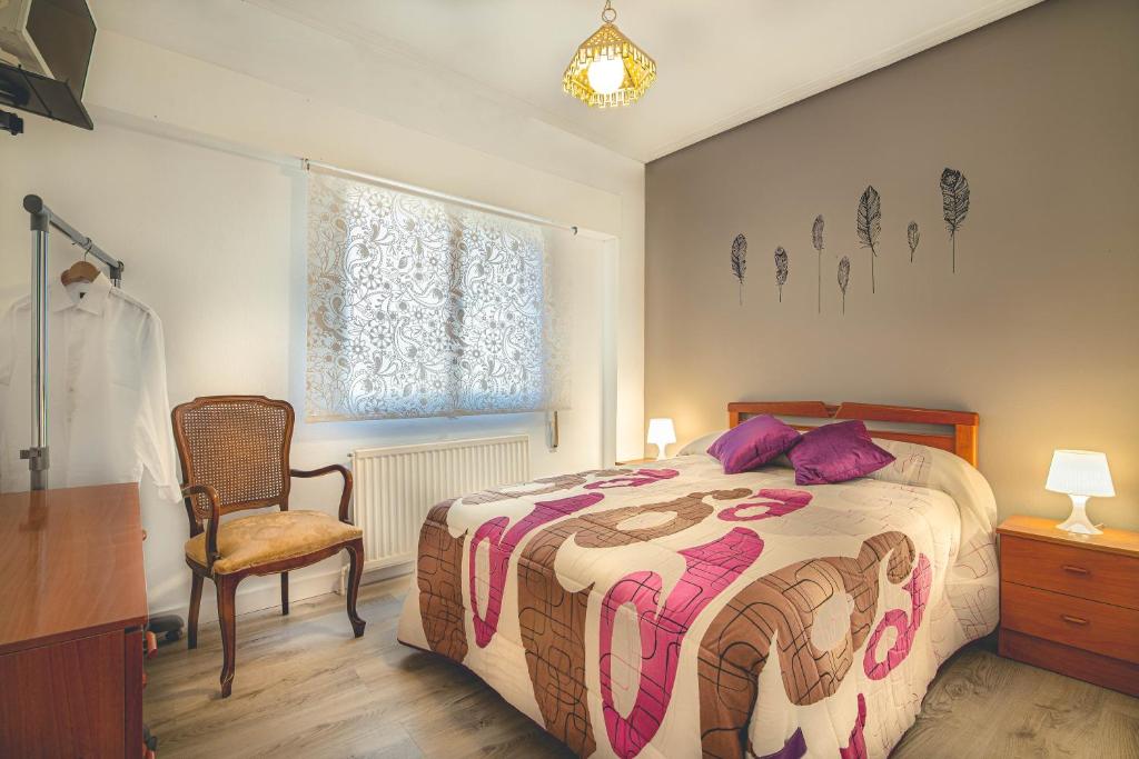 a bedroom with a bed and a chair and a window at Casa El Trinquete in Cenicero